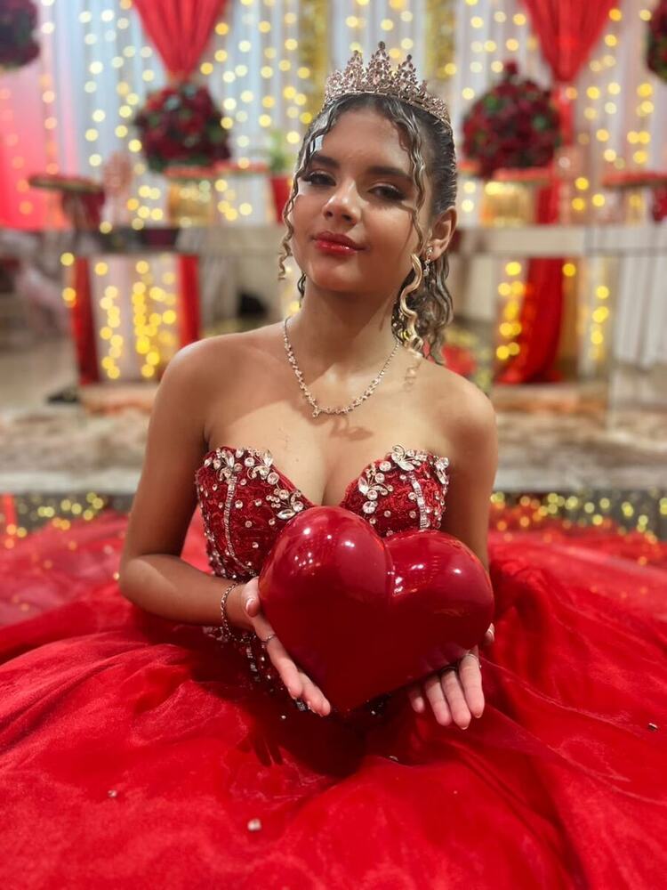 Debutante de vermelho segurando um coração