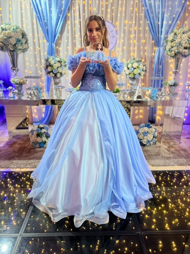 Debutante de azul-claro em frente à mesa decorada